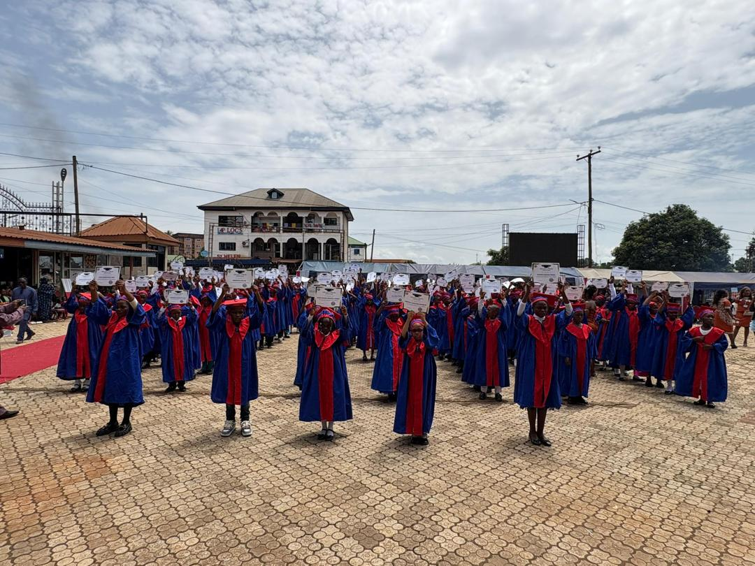 Graduating pupils raising their certificates