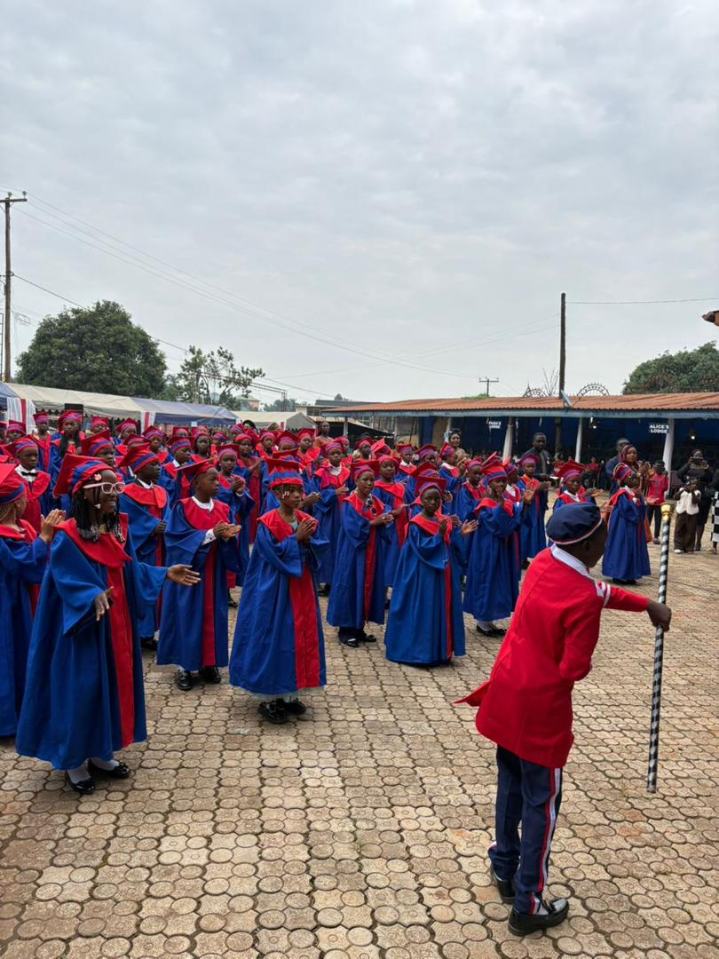 Graduating class in gowns led by the drum major
